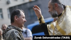 Священник благословляет российского полковника Игоря Гиркина (Стрелкова), который в то время был одним из главарей группировки «ДНР», которая в Украине признана террористической. Оккупированный Донецк, 10 июля 2014 года