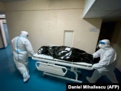 Two men transport a COVID-19 patient's dead body to the morgue at the Emergency Institute in Chisinau.