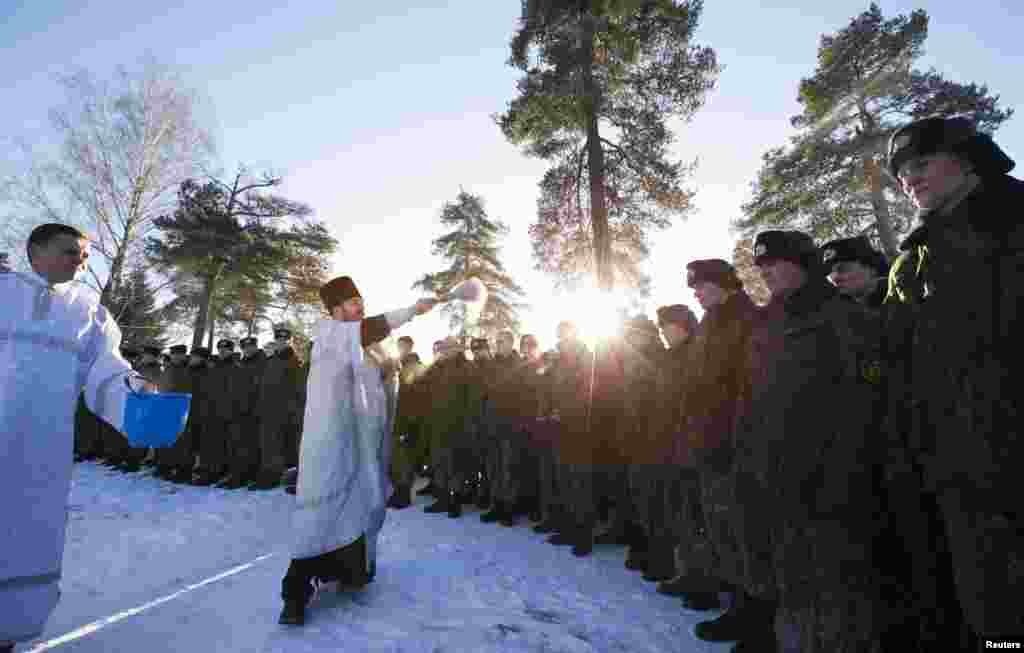 Belarusian security forces take part in a service near an Orthodox church at a military base in Minsk.