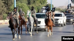 Исламистские боевики в северной провинции Сирии Ракка. 30 июня 2014 года.