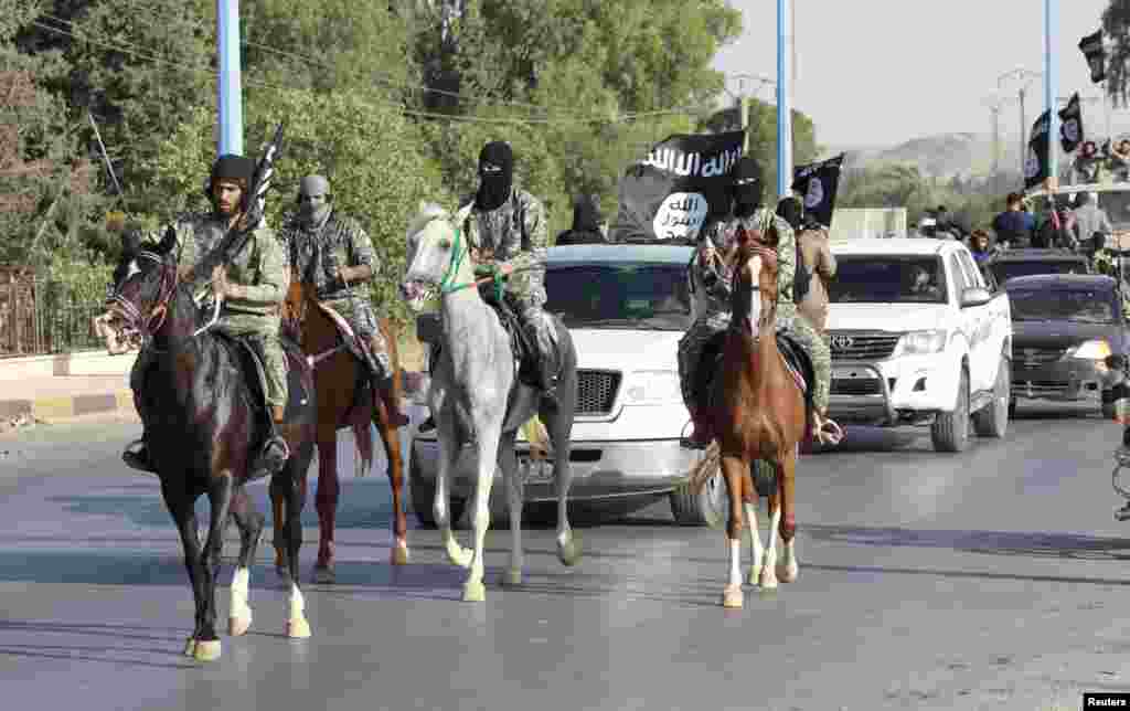 Militant Islamist fighters ride horses as they take part in a military parade along the streets of Syria&#39;s northern Raqqa Province on June 30. (Reuters)