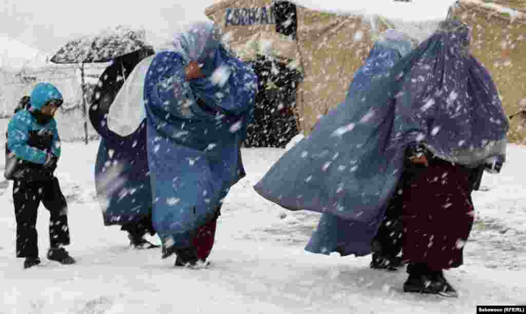 Women arrive to pick up aid packages, which include blankets and warm winter clothes for children, distributed by the UN&#39;s refugee agency.