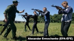 Инструктор учит школьников из оккупированного Донецка обращаться с оружием. 30 мая 2018 года