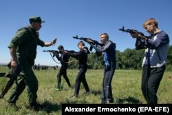 Военный инструктор из вооруженной группировки «ДНР», поддерживаемой Россией, учит школьников пользоваться оружием. Оккупированный Донецк, май 2018 года