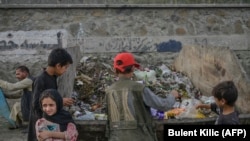 کودکان افغان در جست‌وجوی مواد غذایی در یک زباله دان در کابل 