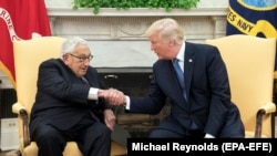 President Donald J. Trump shakes hands with former Secretary of State Henry Kissinger during their meeting in the Oval Office of the White House, in Washington, DC, 10 October 2017.