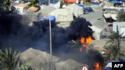 Дым над лагерем оппозиции на центральной площади Манамы