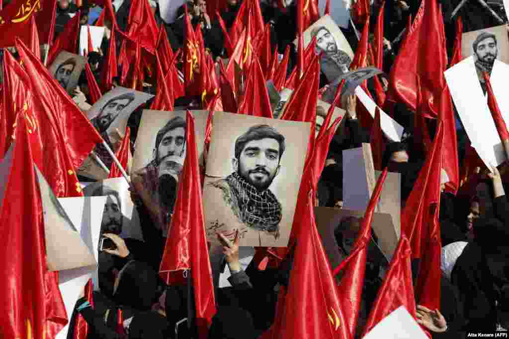 Mourners raise portraits of Mohsen Hojaji, a young member of Iran&#39;s elite Islamic Revolutionary Guards Corps, who was beheaded in Syria by Islamic State militants, during a funerary procession for him in Tehran on September 27. (AFP/Atta Kenare)