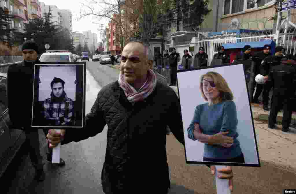 Nj&euml; gazetar turk mban portretin e gazetares amerikane Marie Kolvin dhe at&euml; t&euml; fotografit francez Remit Ochlik, t&euml; vrar&euml; n&euml; Siri... 