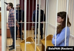 Journalist Katsyaryna Barysevich (right) and doctor Artsyom Sarokin stand inside a defendants' cage during a court hearing in Minsk on March 2 in their trial for sharing information about a slain protester.