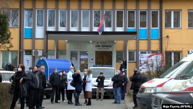 Qytetarët qëndrojnë pranë spitalit në Mitrovicë të Veriut, ku po administrohen vaksinat kundër koronavirusit, që u sollën nga Serbia.