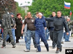 Пророссийские ополченцы ведут пленного в Донецке
