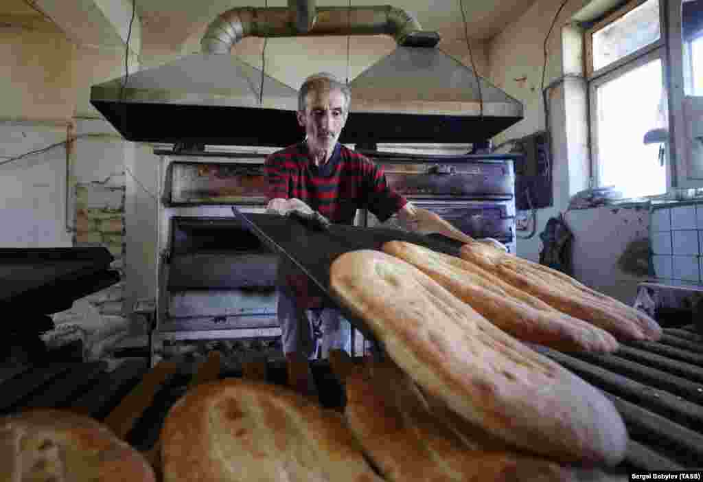 Житель Степанакерта (Ханкенди), столице самопровозглашенной Нагорно-Карабахской республики, печет хлеб. Большую часть продуктов питания сепаратистский регион получает от Армении, его сельскохозяйственный сектор был разрушен еще во время военного конфликта в 1992-1994 годах. Фото 9 октября 2020