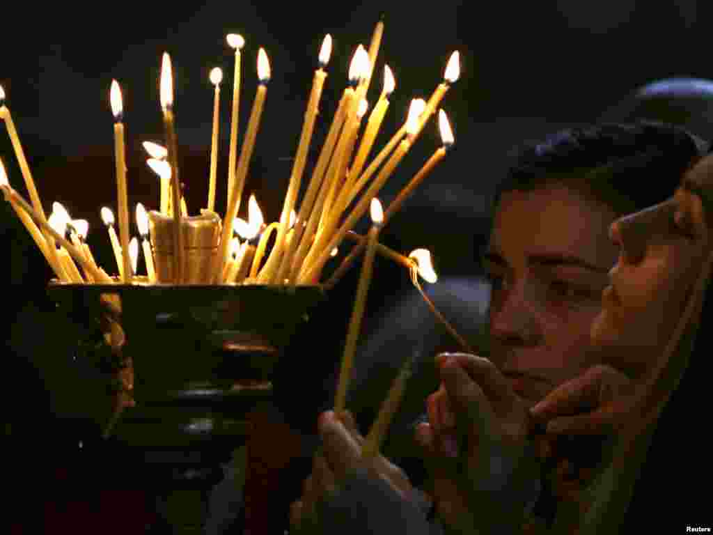 People light candles inside the Svetitskhoveli Cathedral in Georgia's ancient capital of Mtskheta, outside Tbilisi, on October 14. Georgia marked the 1,700th anniversary of Svetitskhoveli Cathedral and the 1,000th anniversary of its first reconstruction. Photo by David Mdzinarishvili for Reuters