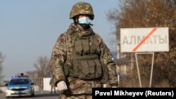 A Kazakh serviceman wearing a protective mask stands guard at a checkpoint following the declarations of a coronavirus lockdown in Almaty, Kazakhstan. 