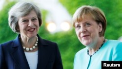 London iki qadının - Angela Merkel (sağda) və Theresa May-in daha asan dil tapacağına inanır