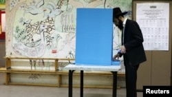 Un evreu ultraortodox votează la o secție electorală din colonia evreiască Kochav Ya'acov, în Cisiordania.