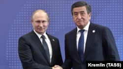 Russian President Vladimir Putin (left) shakes hands with his Kyrgyz counterpart, Sooronbai Jeenbekov, during a welcoming ceremony in Bishkek on November 28.