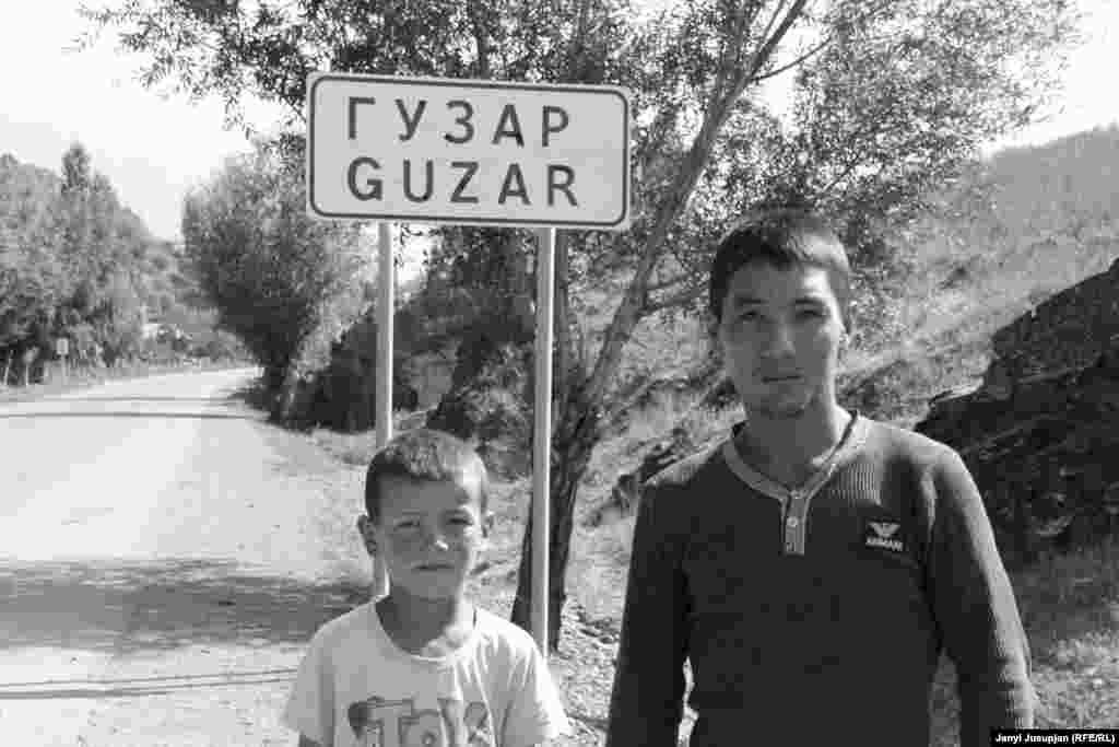 These children say their village used to be called Dombrachy, Kyrgyz for "drummer," but was renamed Guzar in Tajik. But they also pointed to a sign on the opposite side of the street, where the name Guzar is crossed out, indicating the edge of the village. The children claimed that the sign meant that the village hadn't been renamed after all.