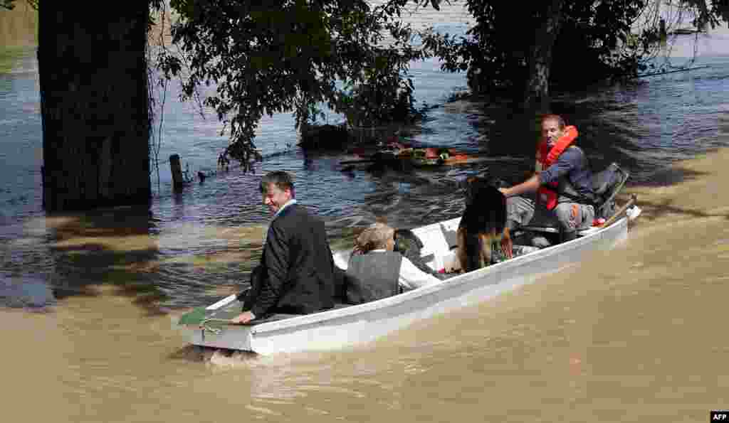 Residents of Gunja, eastern Croatia, ride a boat through flooded streets.