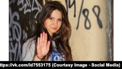 In the background is a wall with graffiti including "14/88," frequently used as code among white supremacists and neo-Nazi groups for a 14-word racist slogan and a reference to the notorious Nazi salute ("Heil Hitler") whose initials repeat the eighth letter of the alphabet.