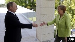Президент России Владимир Путин приветствует канцлера ФРГ Ангелу Меркель в резиденции "Бочаров Ручей".