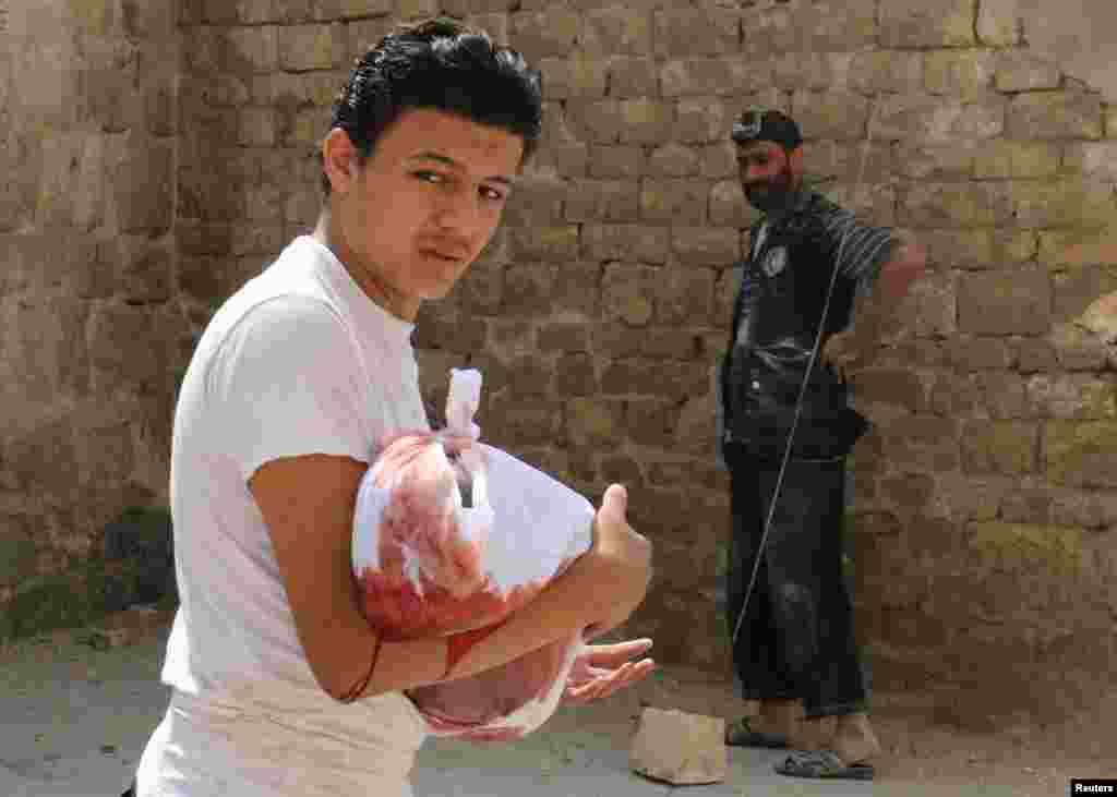 A man carries the body of a dead child after an air strike in the rebel held Bab al-Nairab neighborhood of Aleppo, Syria. (Reuters/Abdalrhman Ismail)
