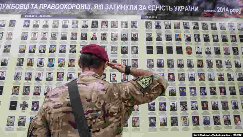 Військовий віддає честь біля меморіалу загиблих бійців на стіні Михайлівського собору&nbsp; 
