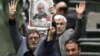 Iranian lawmakers holding pictures of slain Iran's Qods Force leader Qassem Soleimani as they chant 'death to America', during a parliament session in Tehran, January 7, 2020