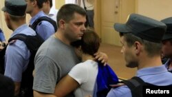 Pyotr Ofitserov embraces his wife after the announcement of the verdict in Kirov on July 18.