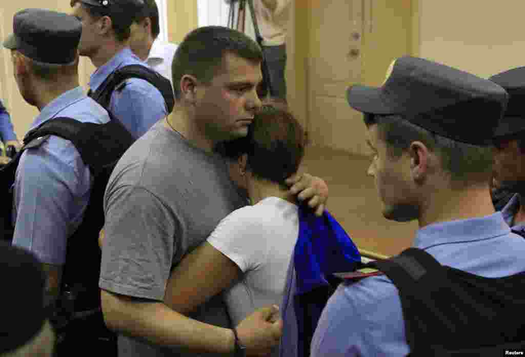 Pyotr Ofitserov (left), Navalny&#39;s co-defendant, embraces his wife after the announcement of the verdict in Kirov.