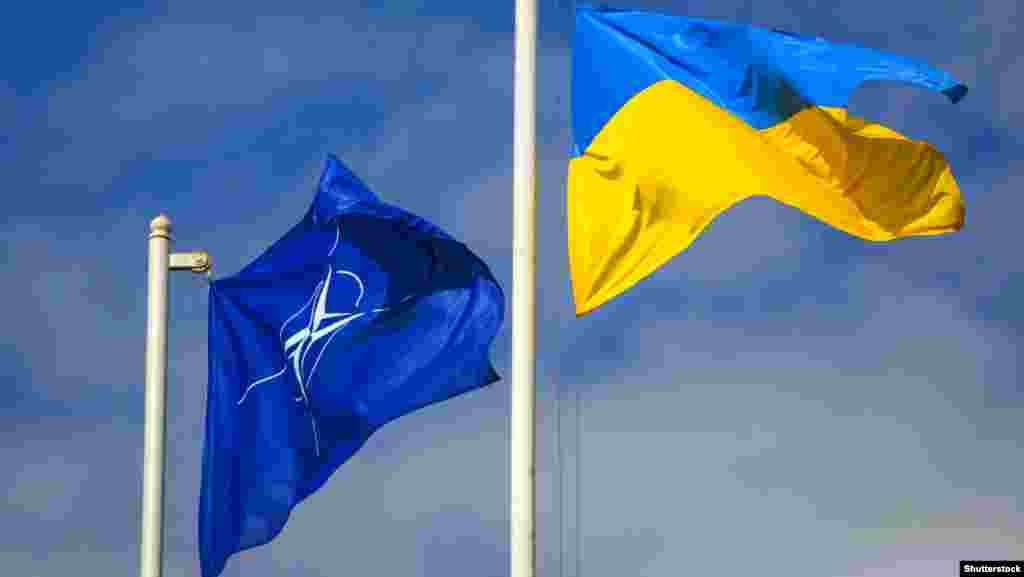 Национальный флаг Украины рядом с флагом Организации Североатлантического договора (НАТО) во время церемонии открытия международных учений спасательных служб «Украина-2015», в которых принимают участие государства-члены НАТО и партнеры альянса