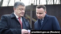 Polish President Andrzej Duda (right) talks with Ukrainian President Petro Poroshenko during a visit to the memorial for the victims of totalitarianism in Kharkiv, Ukraine, in December 2017.