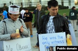 Гражданский активист Бахытжан Торегожина и независимый журналист Лукпан Ахмедьяров проводят акцию протеста против убийства ключевого свидетеля по делу о расстреле демонстрантов в Жанаозене. Вашингтон, 17 октября 2012 года.