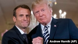 U.S. President Donald Trump (right) and French President Emmanuel Macron embrace at the conclusion of a news conference in the East Room of the White House in Washington, D.C., on April 24.