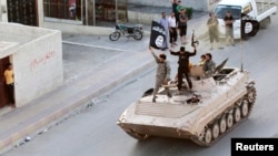 Militant Islamist fighters take part in a military parade along the streets of northern Raqqa Province in June.