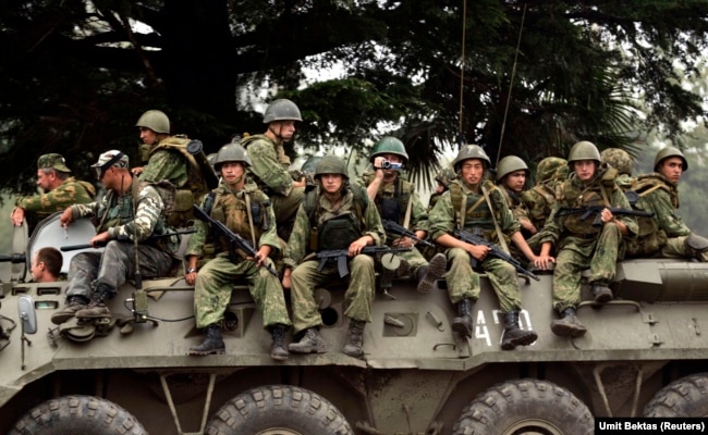 Soldati russi su un veicolo militare lasciano una base nella città georgiana occidentale di Senaki il 19 agosto 2008.