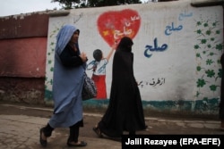 Ауған әйелдері "бейбітшілік" сөзі жазылған графити жанынан өтіп барады. Герат, 3 мамыр 2021 жыл.
