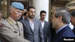 Syria's Deputy Foreign Minister Faisal al-Miqdad (right) greets Major General Robert Mood, chief of the United Nations Supervision Mission in Syria, in Damascus on June 5.