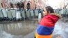 Armenia -- An opposition protester stands against the backdrop of riot police protecting the main Armenian government building in Yerevan, December 24, 2020.