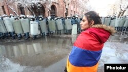 Armenia -- An opposition protester stands against the backdrop of riot police protecting the main Armenian government building in Yerevan, December 24, 2020.