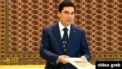 Türkmenistanyň prezidenti Gurbanguly Berdimuhamedow we onuň çaý barada ýazandygy aýdylýan kitaby.