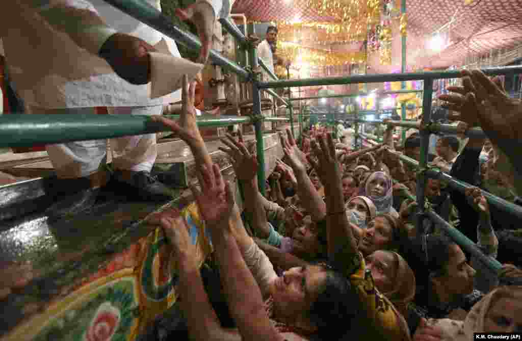 Pakistani women jostle to get free milk at a distribution point during a three-day annual festival celebrating the famous saint Data Ganjbaksh at his shrine in Lahore.&nbsp;