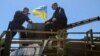 Arseniy Yatsenyuk (right) sits atop an armored vehicle during a visit to a checkpoint near the eastern Ukrainian city of Slovyansk on May 7, 2014.