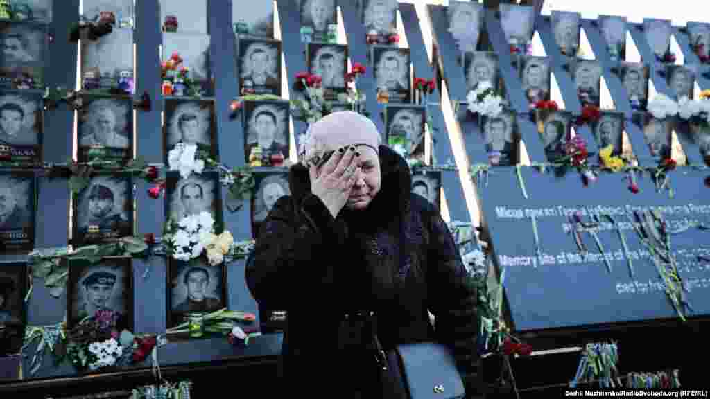 A woman stands before a memorial to those killed in the 2014 Euromaidan uprising on the Alley of the Heroes of the Heavenly Hundred in Kyiv, Ukraine, on February 18. (Serhii Nuzhnenko, RFE/RL)