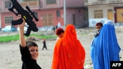 Ойыншық қару ұстаған босқындар лагеріндегі бала. Пәкістан, 19 тамыз 2012 жыл.