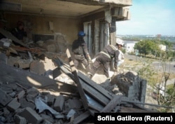 Рятувальники оглядають багатоповерхівку, пошкодженого внаслідок російського ракетного удару, Харків, 8 липня 2026 року