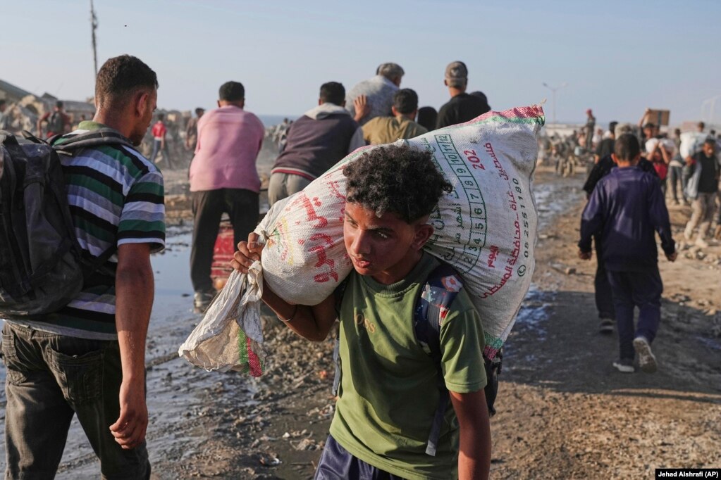 Një djalë palestinez duke bartur një thes me ndihma.