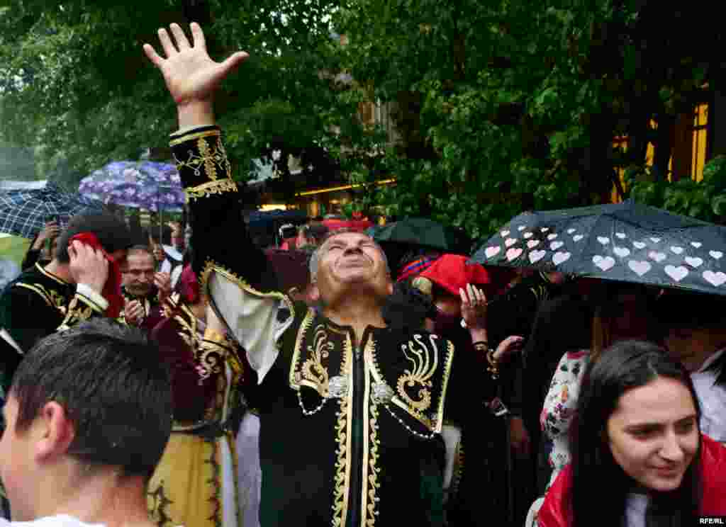 Спустя короткое время после избрания Никола Пашиняна на Ереван обрушился ливень. Люди в национальных костюмах танцуют под дождем.