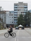 Një person duke kaluar me biçikletë në urën mbi lumin Ibër në Mitrovicë. Fotografi ilustruese nga arkivi. 